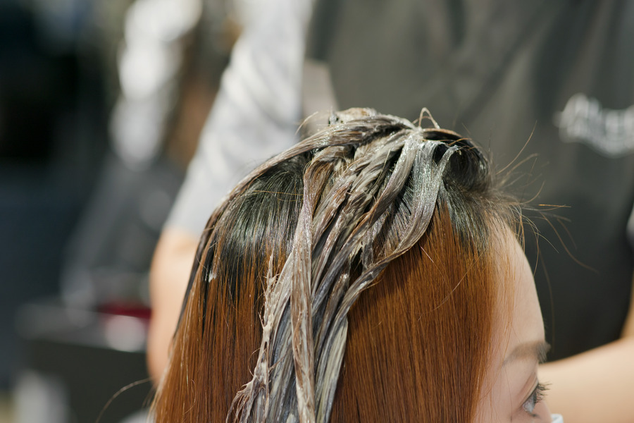 Une bonne patine blonde sur les cheveux secs d'une cliente dans un salon de coiffure