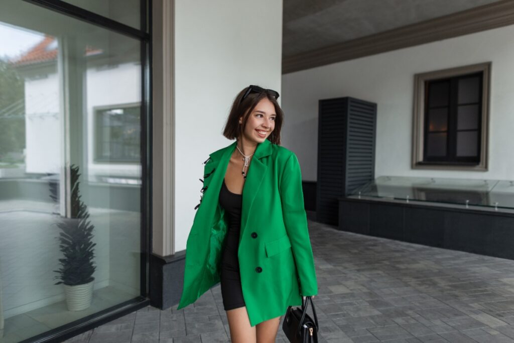 Une femme habillée avec un blazer vert et une robe noire