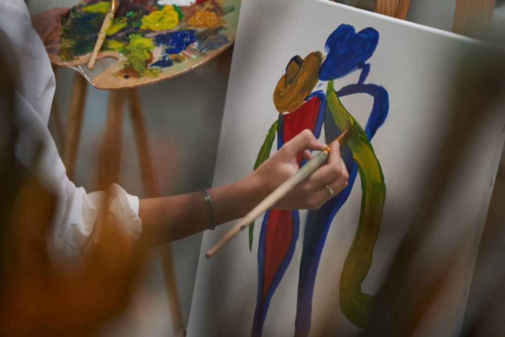 Une personne faisant un portrait sur un tableau pour exprimer un art