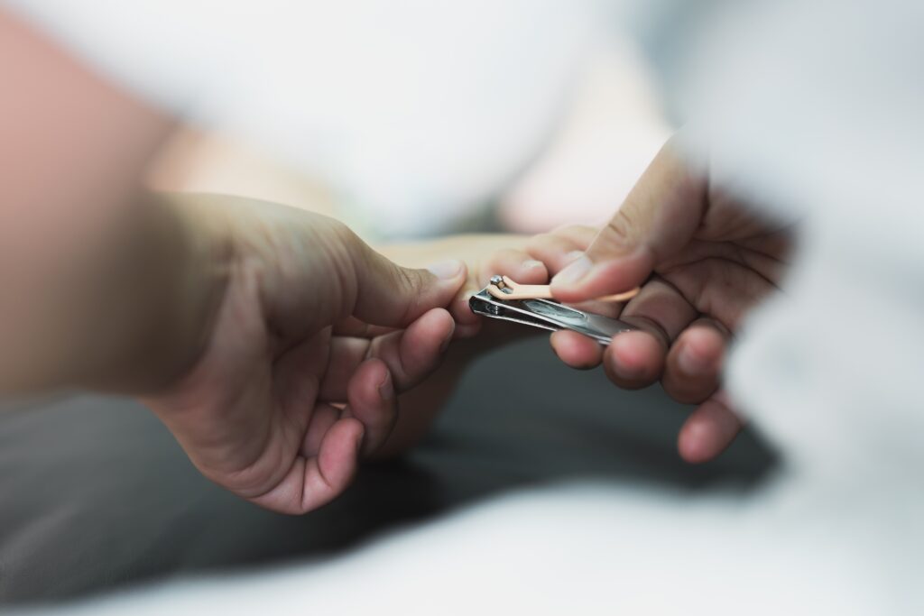 Une personne qui se fait couper les ongles du pied