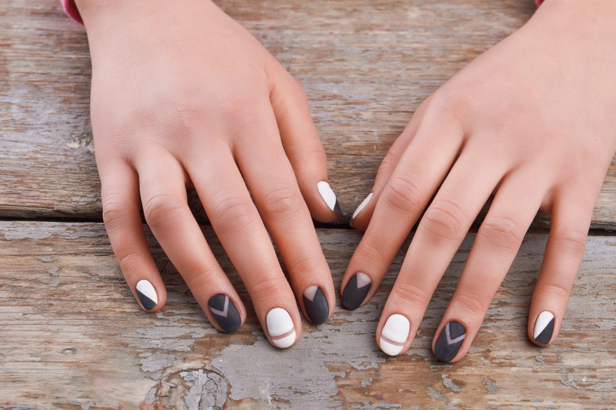 Main d'une femme avec du vernis à ongle