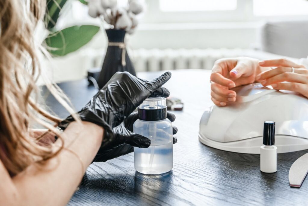 Une esthéticienne qui prépare l'ongle d'une cliente avant la manucure