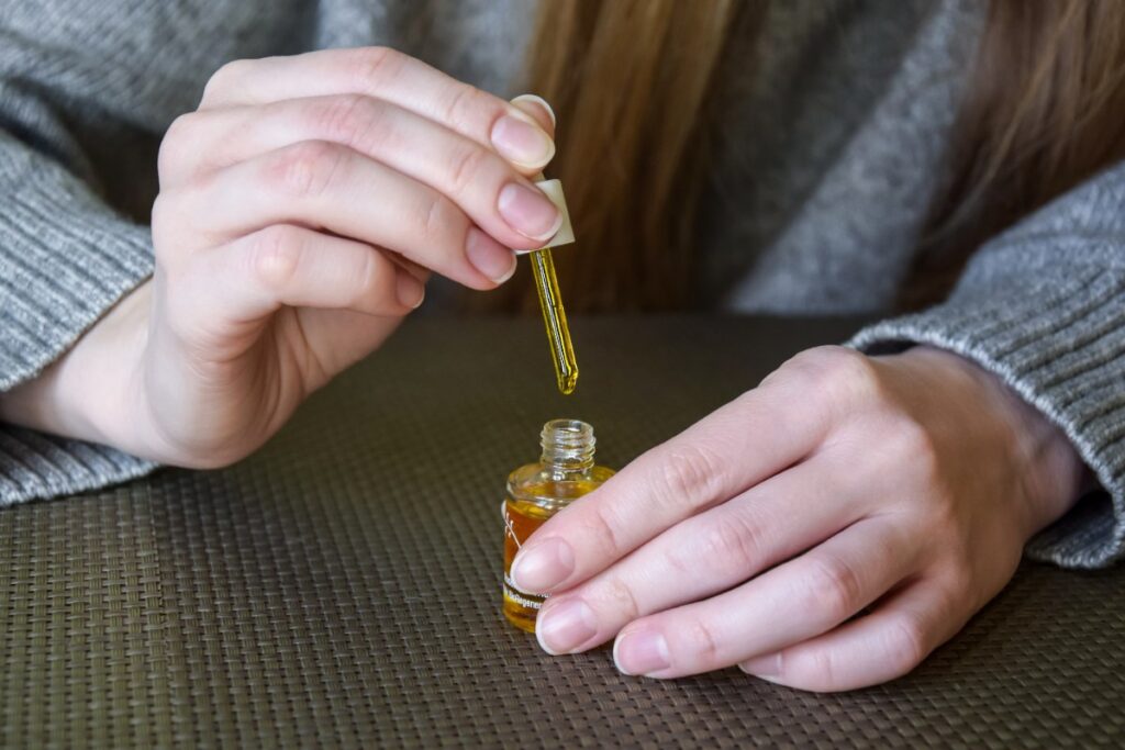 Une femme qui applique de l'huile de ricin sur ses ongles