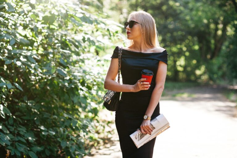 Une femme en robe noire et tient un livre