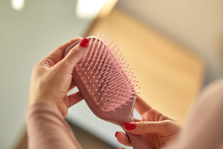 Mains d'une femme avec une brosse à cheveux