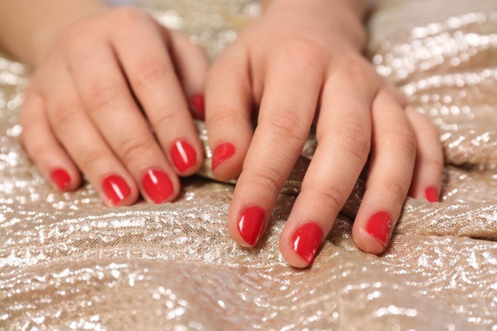Mains avec des ongles courts rouges