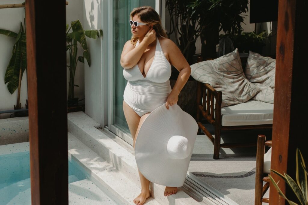 Une femme en maillot de bain tenant un chapeau