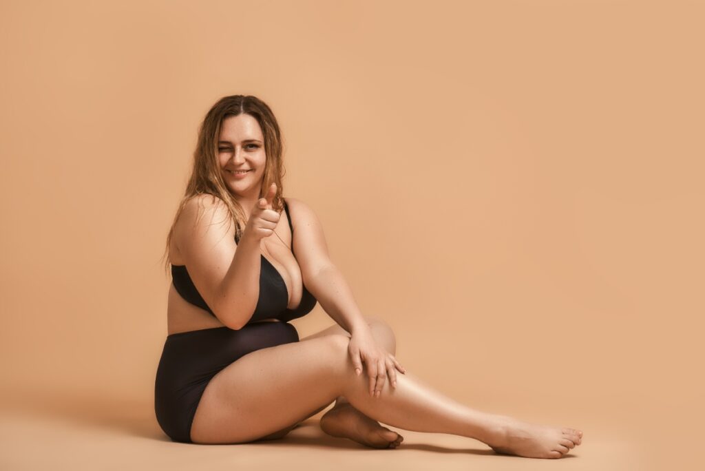 Une femme souriante en maillot de bain noir