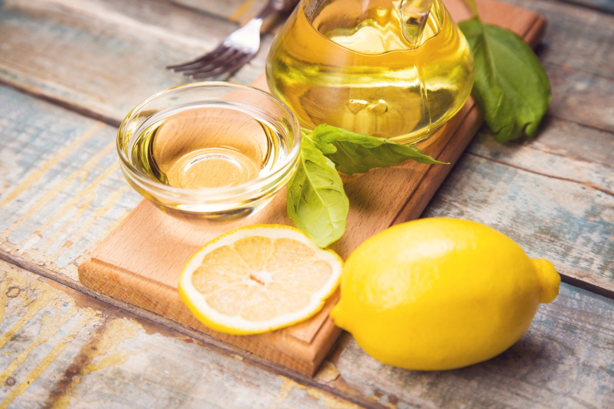 Un citron avec un bol d'huile d'olive pour cuticules
