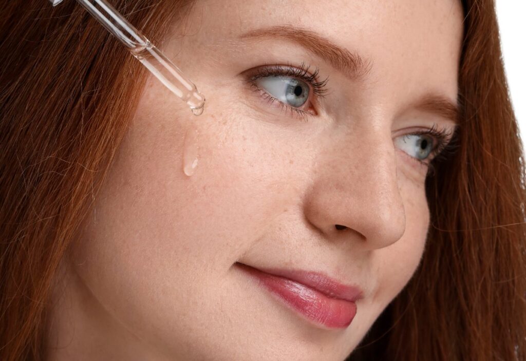 Une femme appliquant du sérum sur le visage