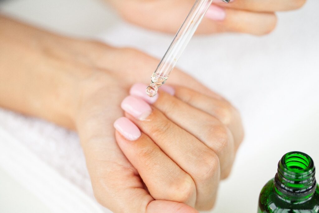 Une femme qui applique de l'huile de ricin sur les ongles
