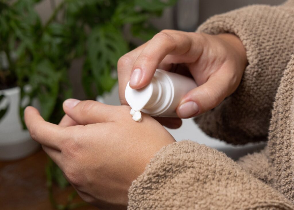 Main appliquant de la crème sur la peau