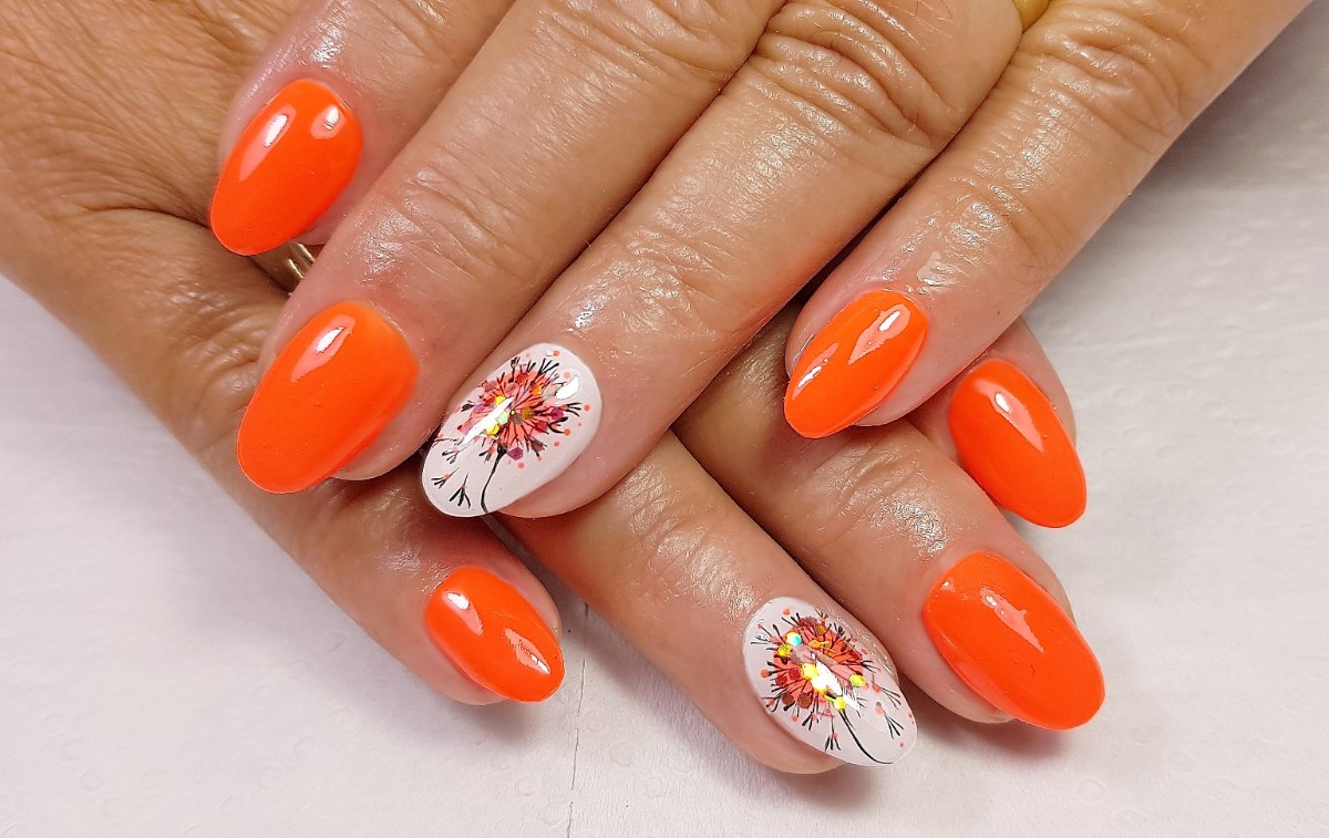 Manucure orangée sur les mains d'une femme