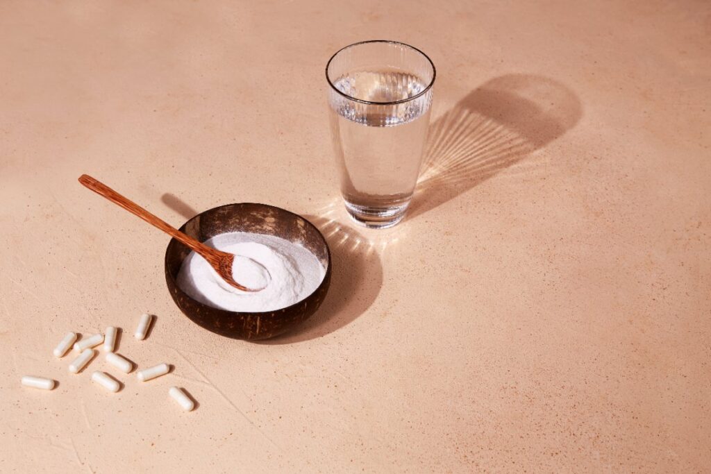 Collagène en poudre dans un bol avec une cuillère et un verre d'eau