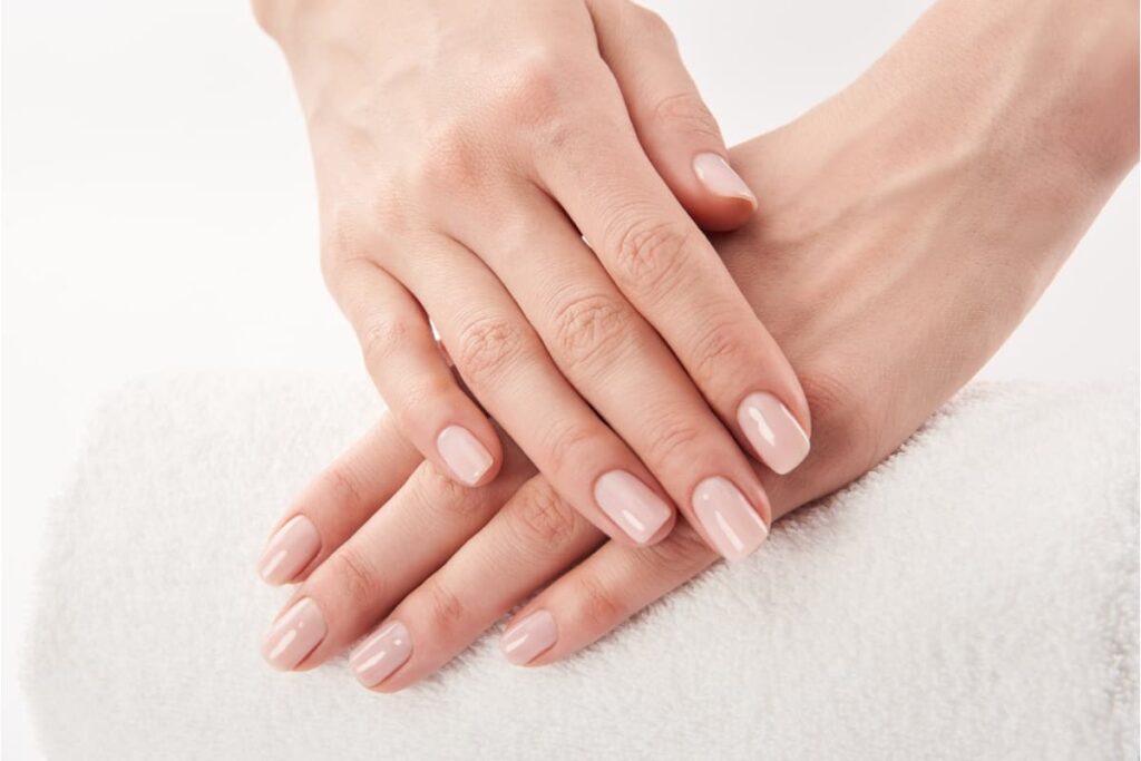Une femme ayant de jolies mains avec les ongles nudes