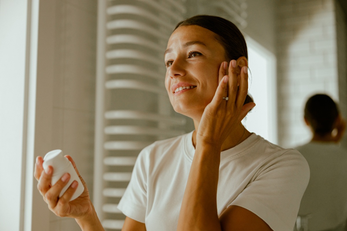 Une femme appliquant de la crème sur le visage