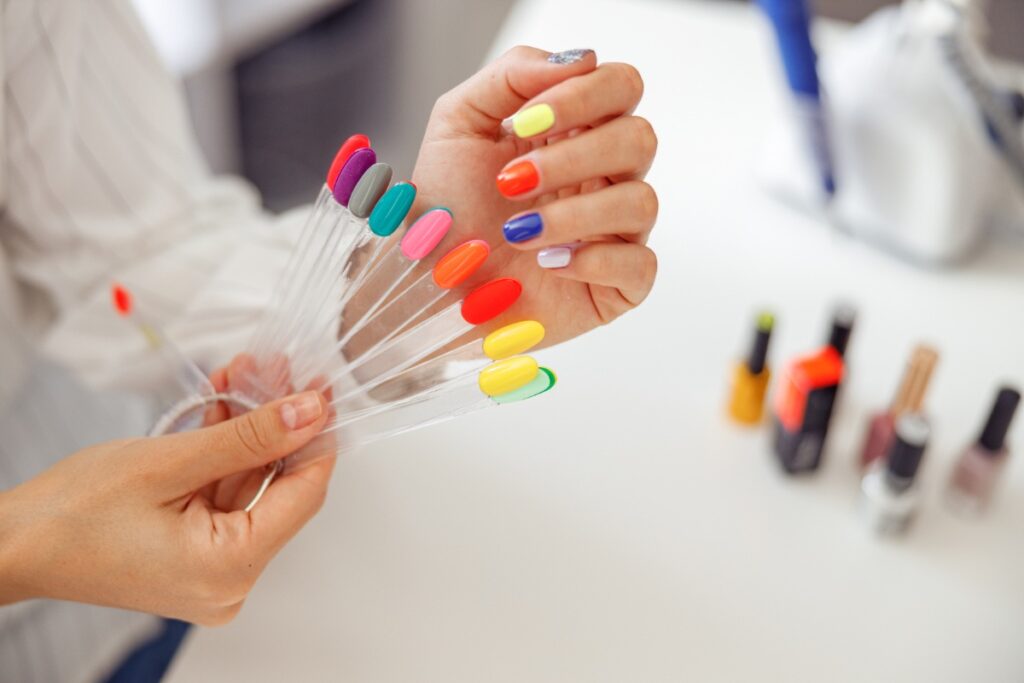 Une femme tenant une palette de vernis à ongles