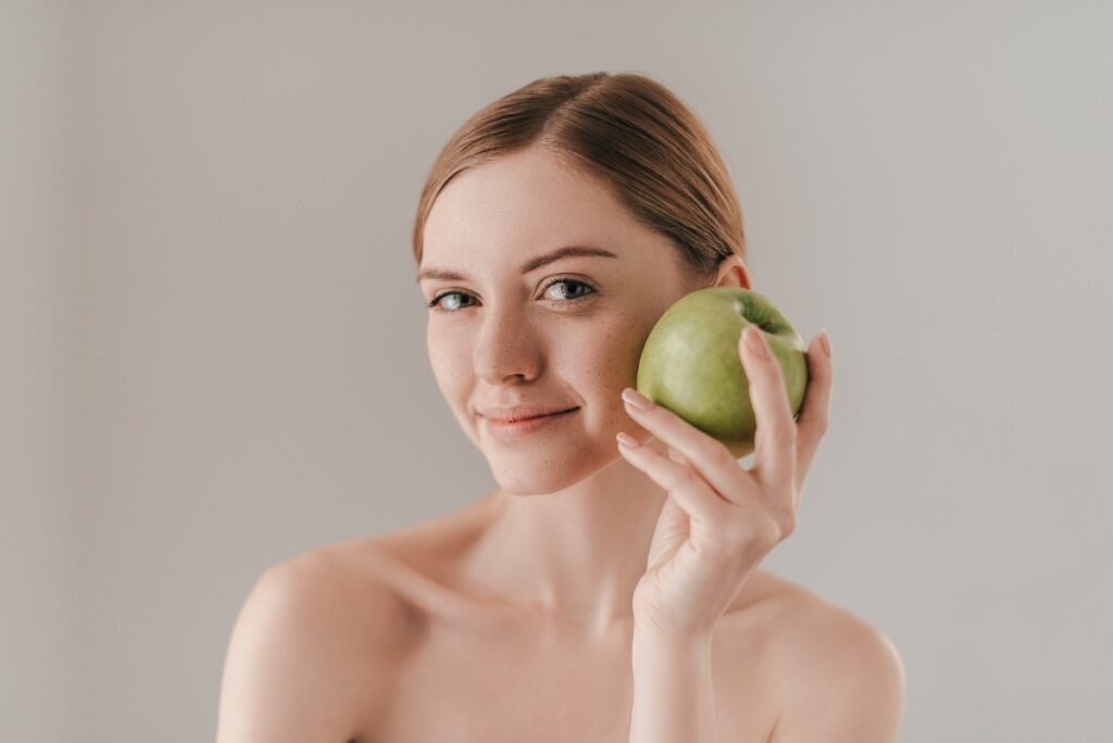 Une femme tenant une pomme verte