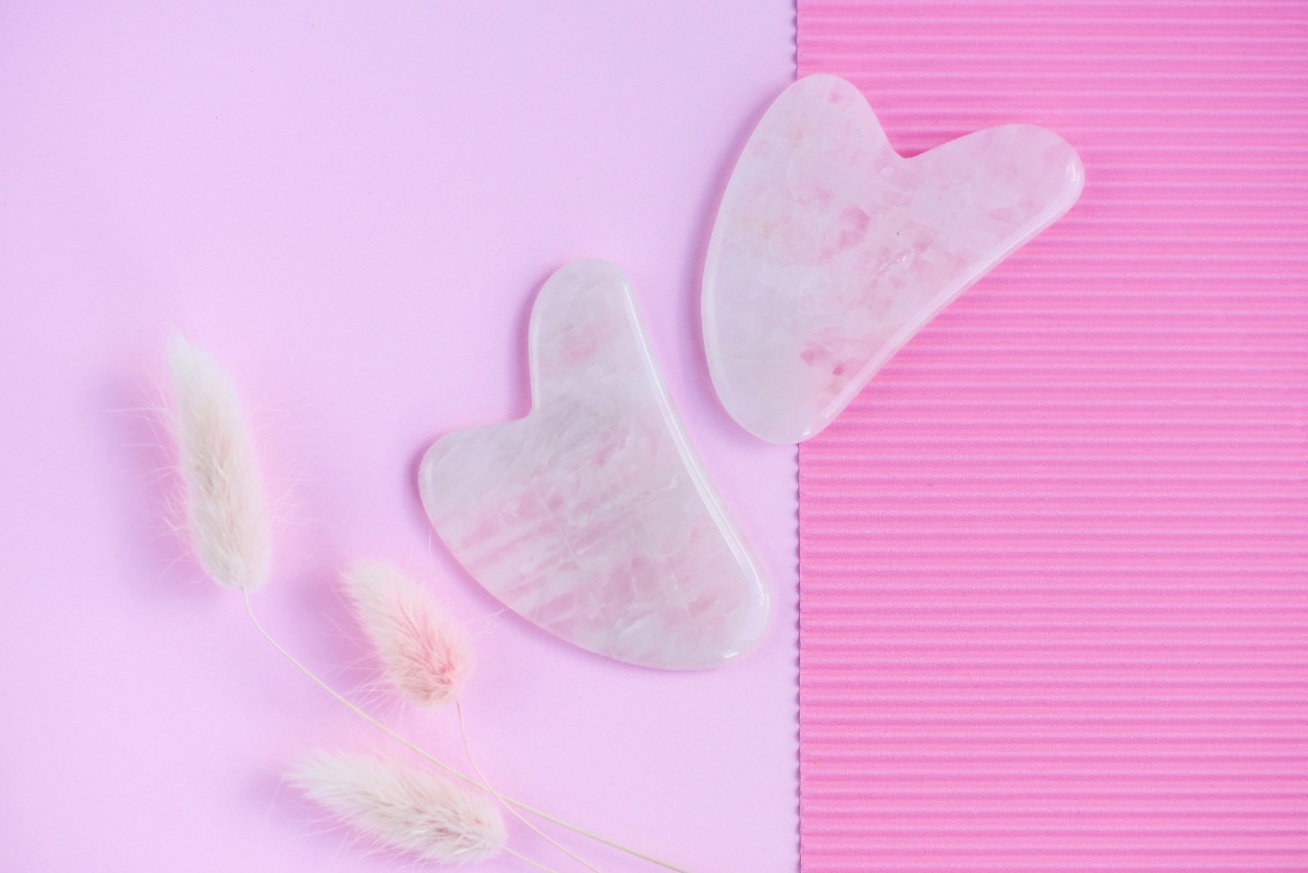 Guasha rose avec des outils pour le soin de visage