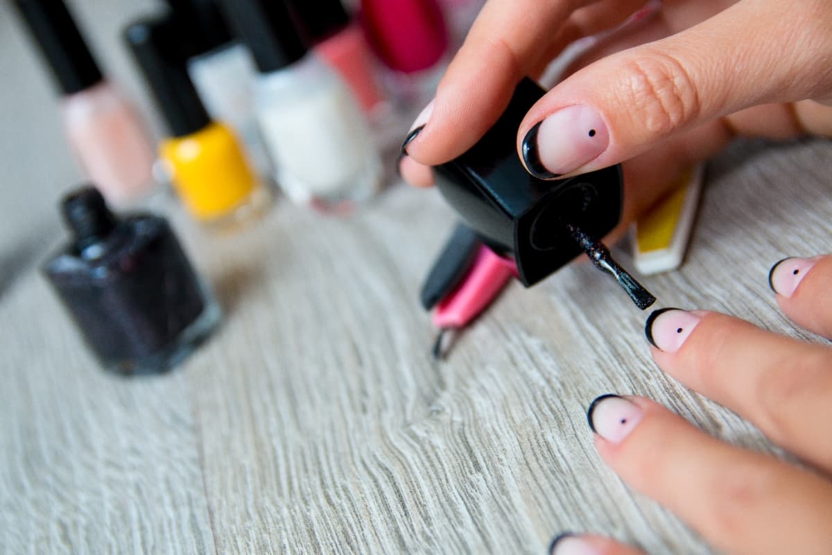 Une femme fait la pose de ses vernis semi-permanents
