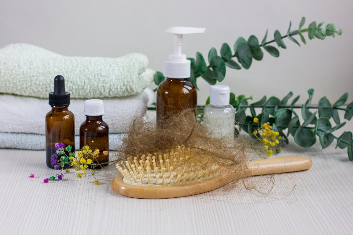 Produits de soins de cheveux avec une brosse et de l'huile sur la table
